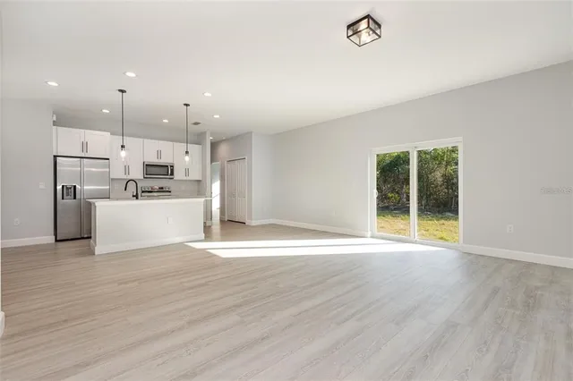 a view of a kitchen with a sink a refrigerator and window