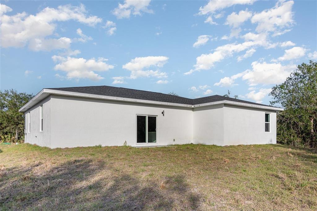 13451 Kaplan Terrace Port Charlotte, FL 33981 - Photo 23 of 27 a view of a white house with a big yard and mountain view in back