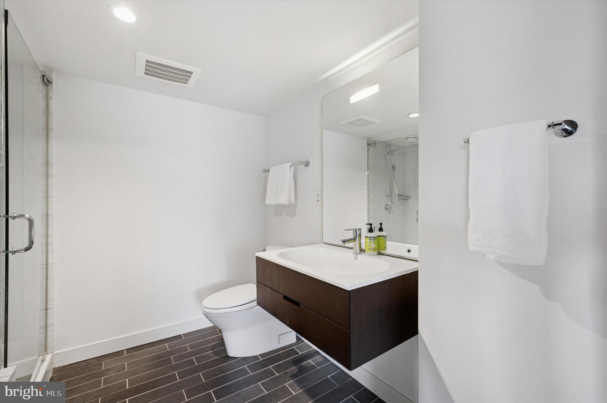1101 Washington Avenue, Unit 306 Philadelphia, PA 19147 - Photo 18 of 25 a bathroom with a double vanity sink mirror and toilet