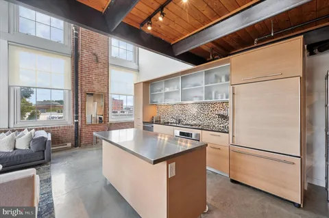 a kitchen with stainless steel appliances granite countertop a sink a stove and a refrigerator