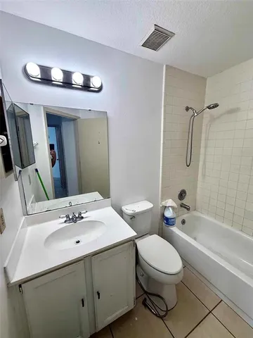 a spacious bathroom with a tub sink and mirror