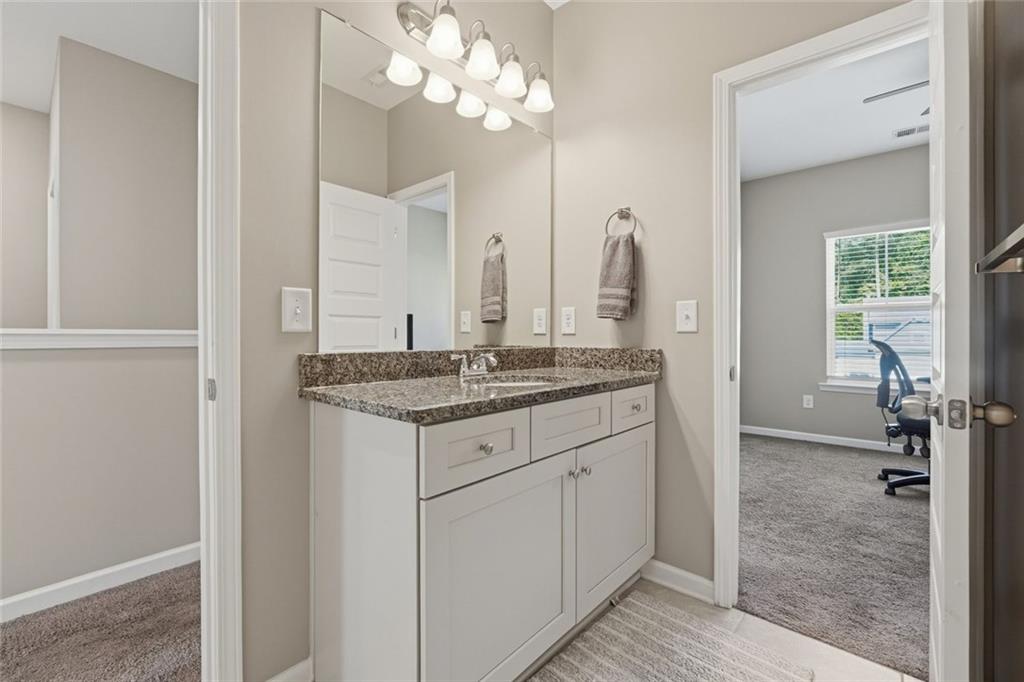 166 Ashbridge Lane Dallas, GA 30132 - Photo 14 of 35 a bathroom with a granite countertop sink a mirror and a vanity