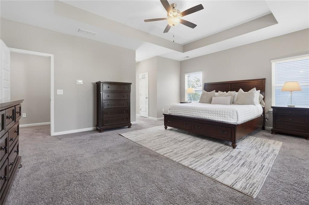 166 Ashbridge Lane Dallas, GA 30132 - Photo 19 of 35 a spacious bedroom with a bed and a chandelier