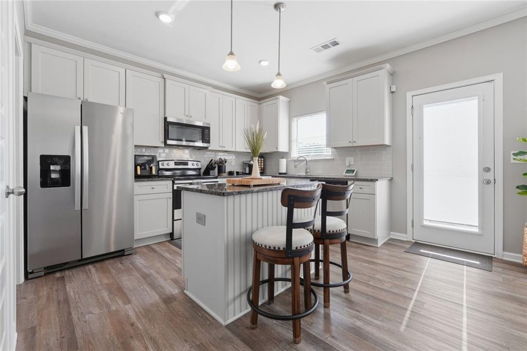 166 Ashbridge Lane Dallas, GA 30132 - Photo 7 of 35 a kitchen with stainless steel appliances a microwave a stove a sink dishwasher a refrigerator with a dining table and chairs