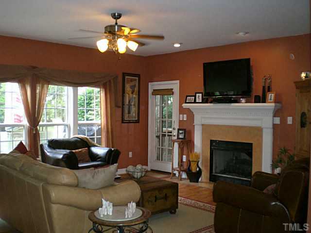 4900 Abbotts Pointe Court Raleigh, NC 27616 - Photo 7 of 25 a living room with furniture a flat screen tv and a fireplace