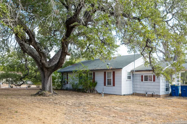 a view of a house with a tree in front of it