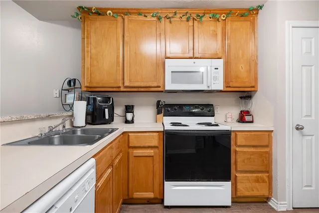 a kitchen with stainless steel appliances granite countertop a stove a sink and a microwave