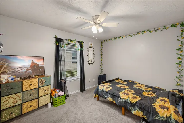 a bedroom with a bed and a flat tv screen on dresser