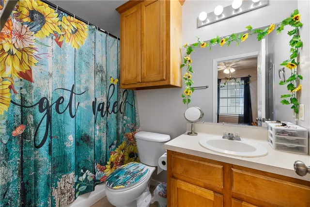 a bathroom with a granite countertop toilet sink and mirror