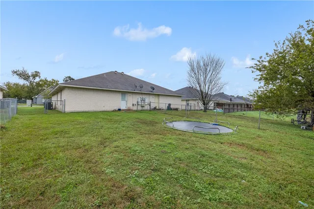 a view of a house with a big yard and palm trees