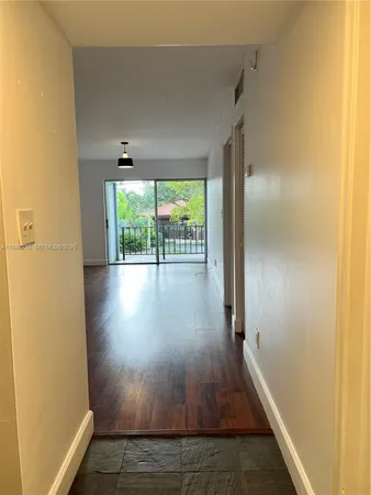 a view of hallway with wooden floor