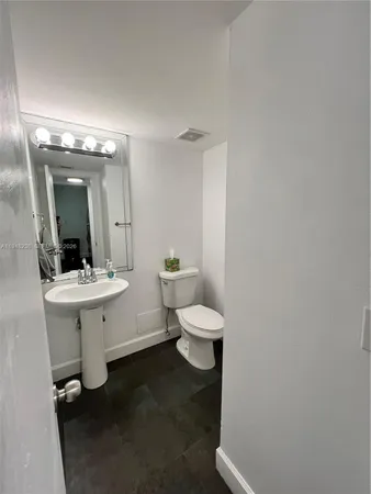 a bathroom with a toilet sink and mirror