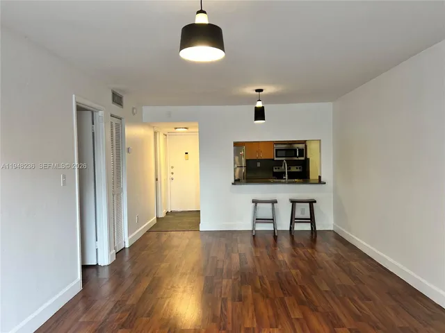 a view of a livingroom with a flat screen tv wooden floor and a ceiling fan
