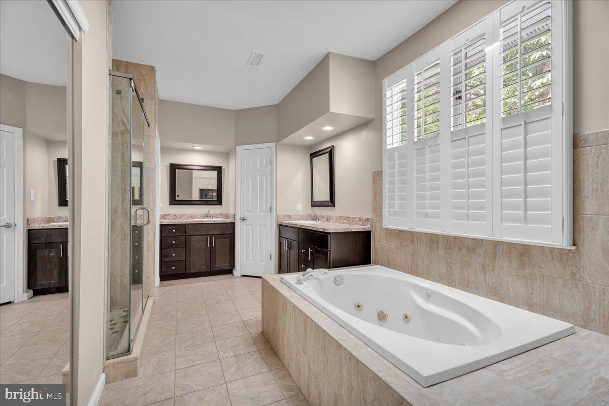 5 Promenade Place Voorhees, NJ 08043 - Photo 17 of 24 a bathroom with a tub a double vanity sink a mirror and a shower