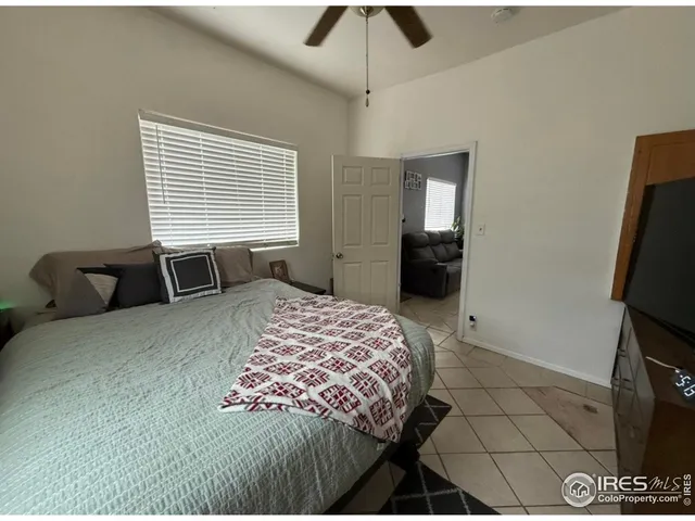 a bedroom with a bed and a flat tv screen on a dresser