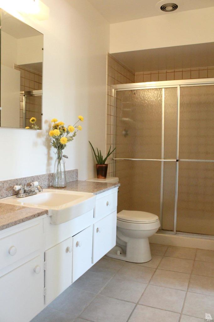 5317 Mildred Street Simi Valley, CA 93063 - Photo 13 of 16 a bathroom with a granite countertop sink a toilet and a mirror