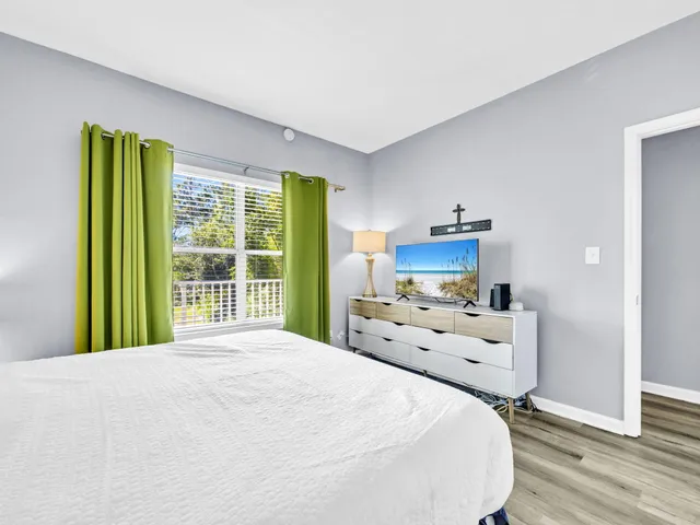 a bedroom with a bed and a large window