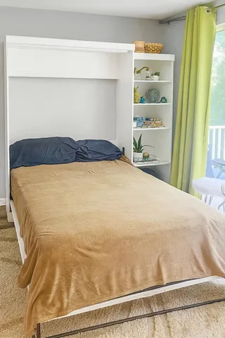 a large bed sitting in a bedroom next to a window