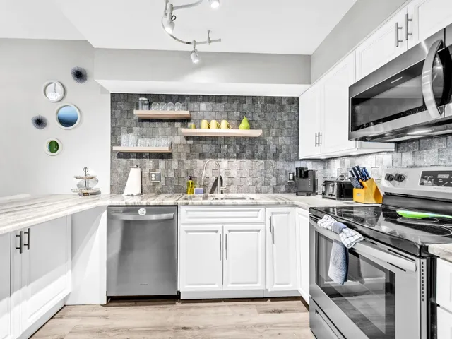 a kitchen with stainless steel appliances a stove microwave and sink