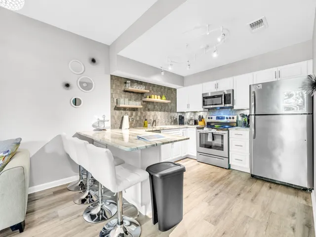 a kitchen with refrigerator cabinets dining table and chairs