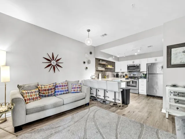 a living room with furniture and kitchen view