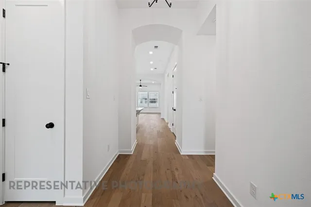 a view of a hallway with wooden floor