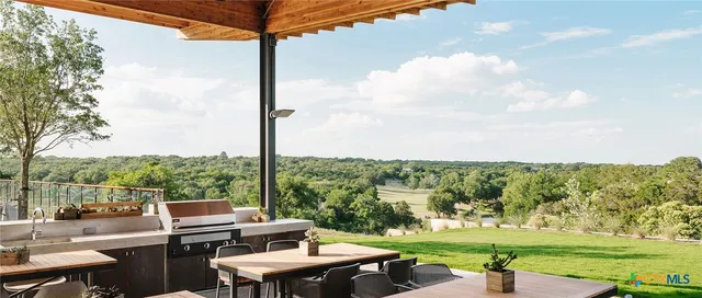 a view of a patio with lawn chairs floor to ceiling window and yard