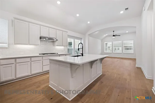 a kitchen with stainless steel appliances a sink stove and cabinets