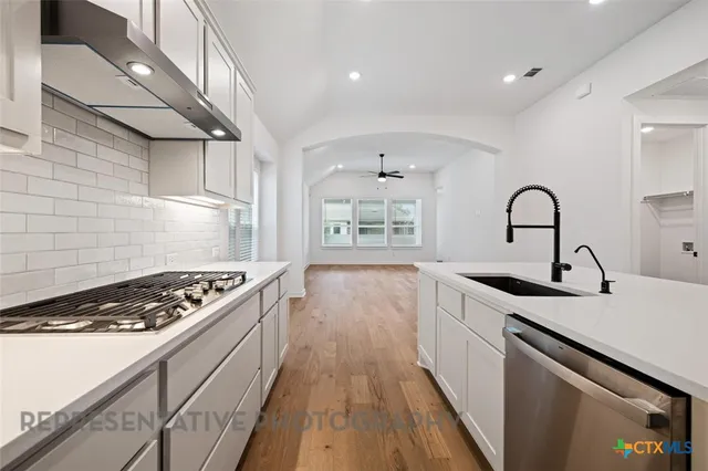 a kitchen with granite countertop a stove and a sink