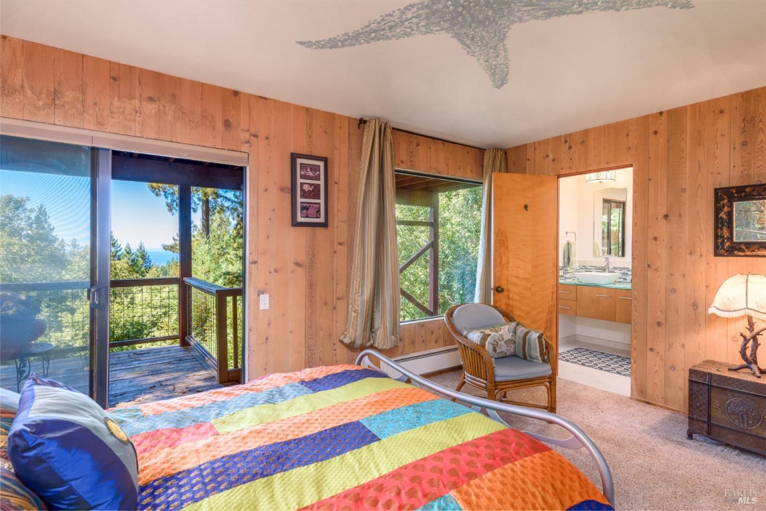 38120 Ocean Ridge Drive Gualala, CA 95445 - Photo 18 of 34 a bedroom with a bed and glass door