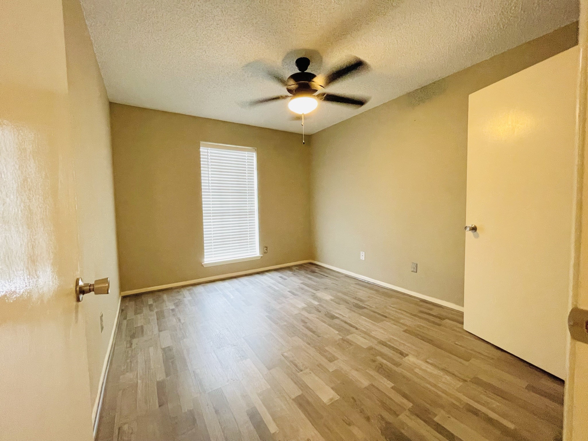 2800 Jeanetta Street, Unit 1702 Houston, TX 77063 - Photo 11 of 23 an empty room with wooden floor fan and windows