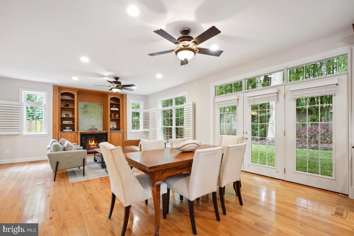 8610 Melwood Road Bethesda, MD 20817 - Photo 15 of 44 a dining room with wooden floor a chandelier fan a glass table and chairs