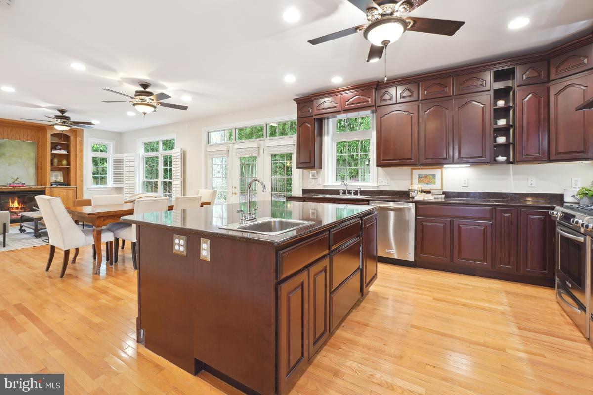 8610 Melwood Road Bethesda, MD 20817 - Photo 17 of 44 a kitchen with stainless steel appliances granite countertop a sink a stove top oven a dining table and chairs