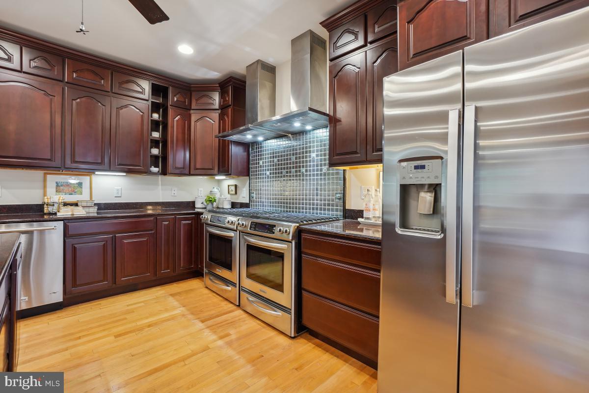 8610 Melwood Road Bethesda, MD 20817 - Photo 18 of 44 a kitchen with stainless steel appliances granite countertop a stove and a refrigerator