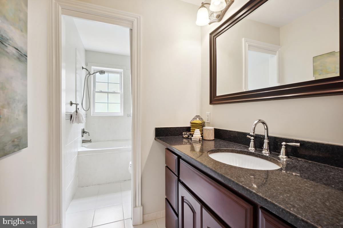 8610 Melwood Road Bethesda, MD 20817 - Photo 29 of 44 a bathroom with a granite countertop sink and a mirror