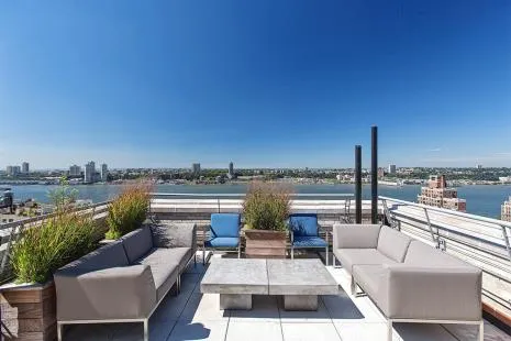 a view of roof deck with couches and city view
