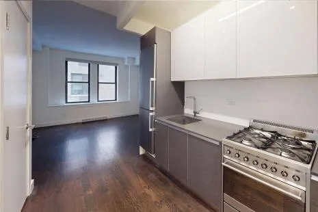 a kitchen with a stove and wooden floor
