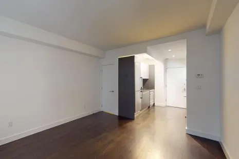 a view of a big room with wooden floor and a kitchen