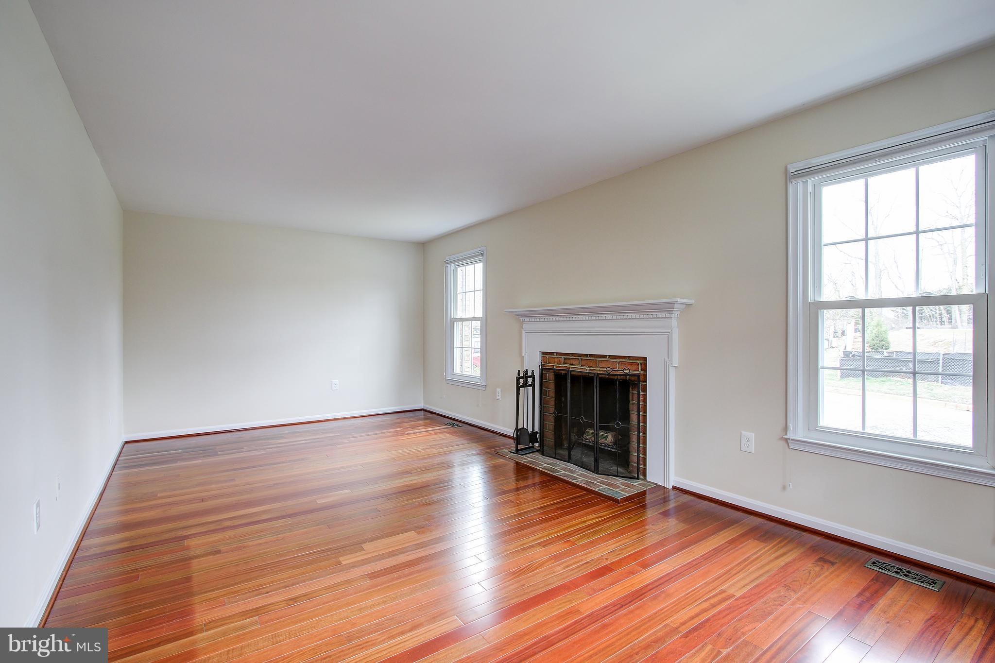 1030 Windrush Lane, Unit 31 Sandy Spring, MD 20860 - Photo 4 of 30 an empty room with wooden floor fireplace and windows