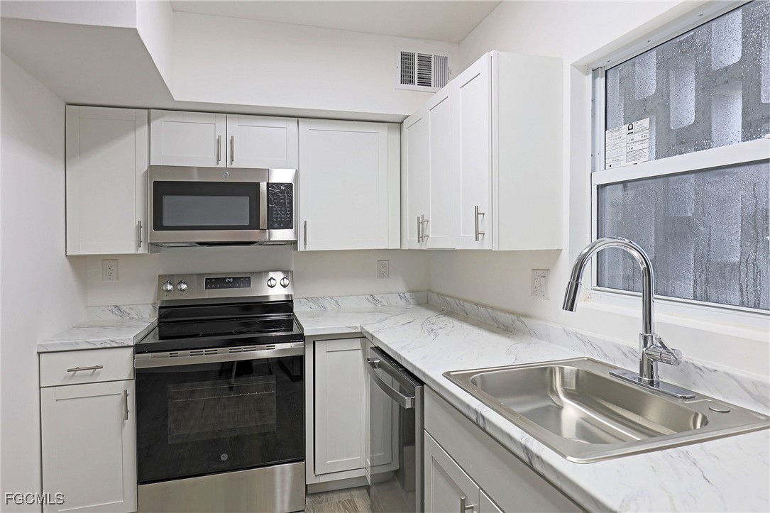 2590 First Street, Unit 105 Fort Myers, FL 33901 - Photo 5 of 13 a kitchen with a sink stove and microwave