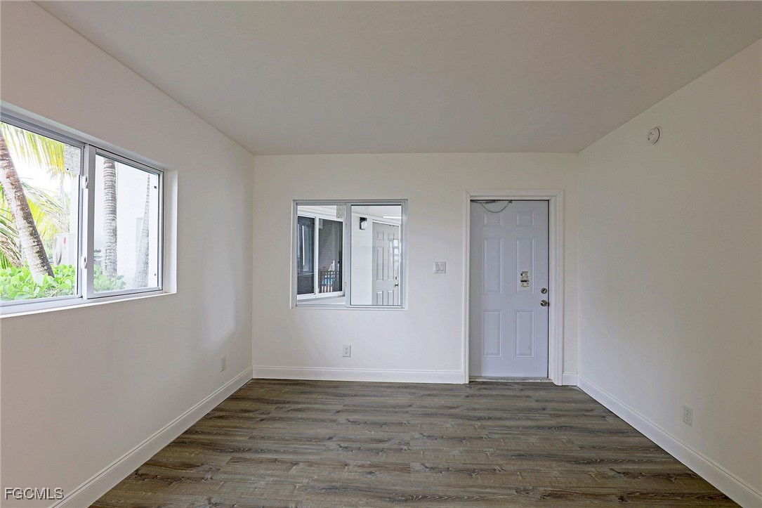 2590 First Street, Unit 105 Fort Myers, FL 33901 - Photo 7 of 13 a view of an empty room with wooden floor and a window