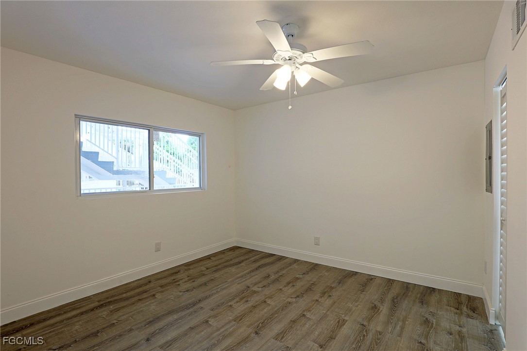 2590 First Street, Unit 105 Fort Myers, FL 33901 - Photo 8 of 13 an empty room with wooden floor and windows