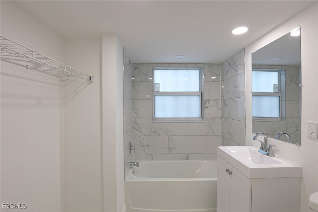2590 First Street, Unit 105 Fort Myers, FL 33901 - Photo 10 of 13 a white bath tub sitting next to a white sink