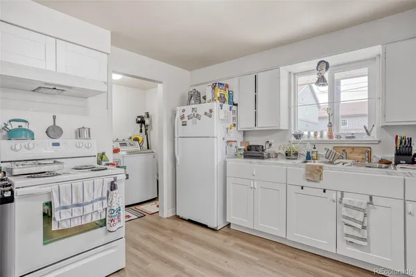 a kitchen with white cabinets and white appliances