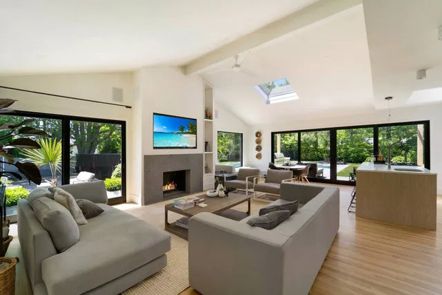 a living room with fireplace furniture and a large window