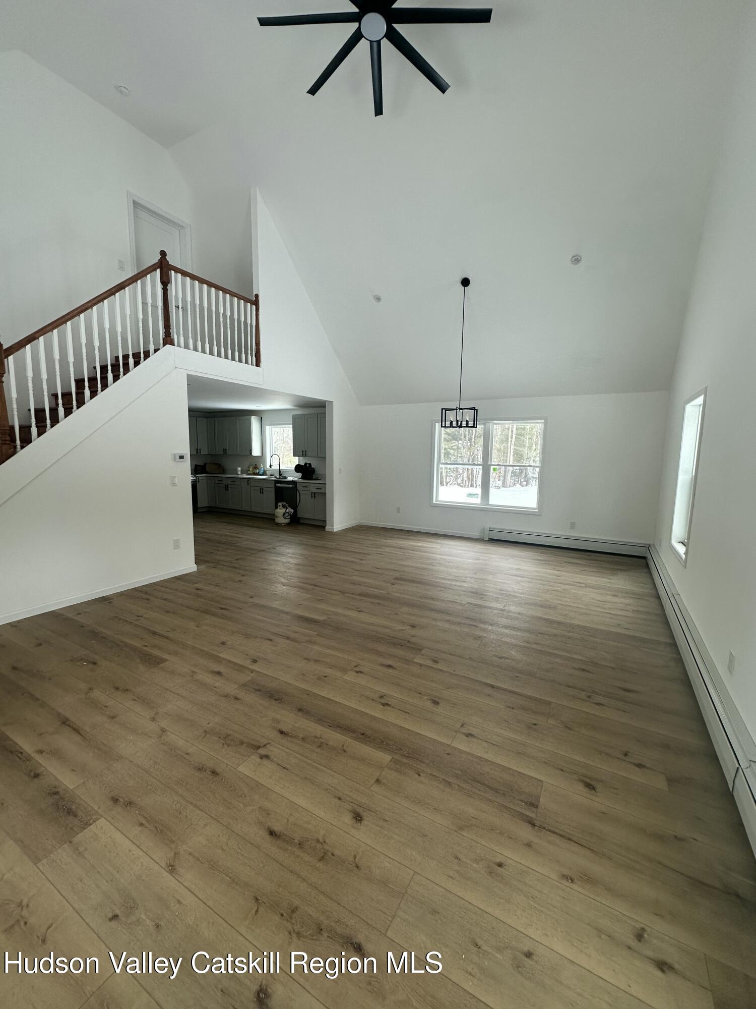 20 Olivers Way Cairo, NY 12413 - Photo 6 of 20 a view of a livingroom with wooden floor a ceiling fan and windows