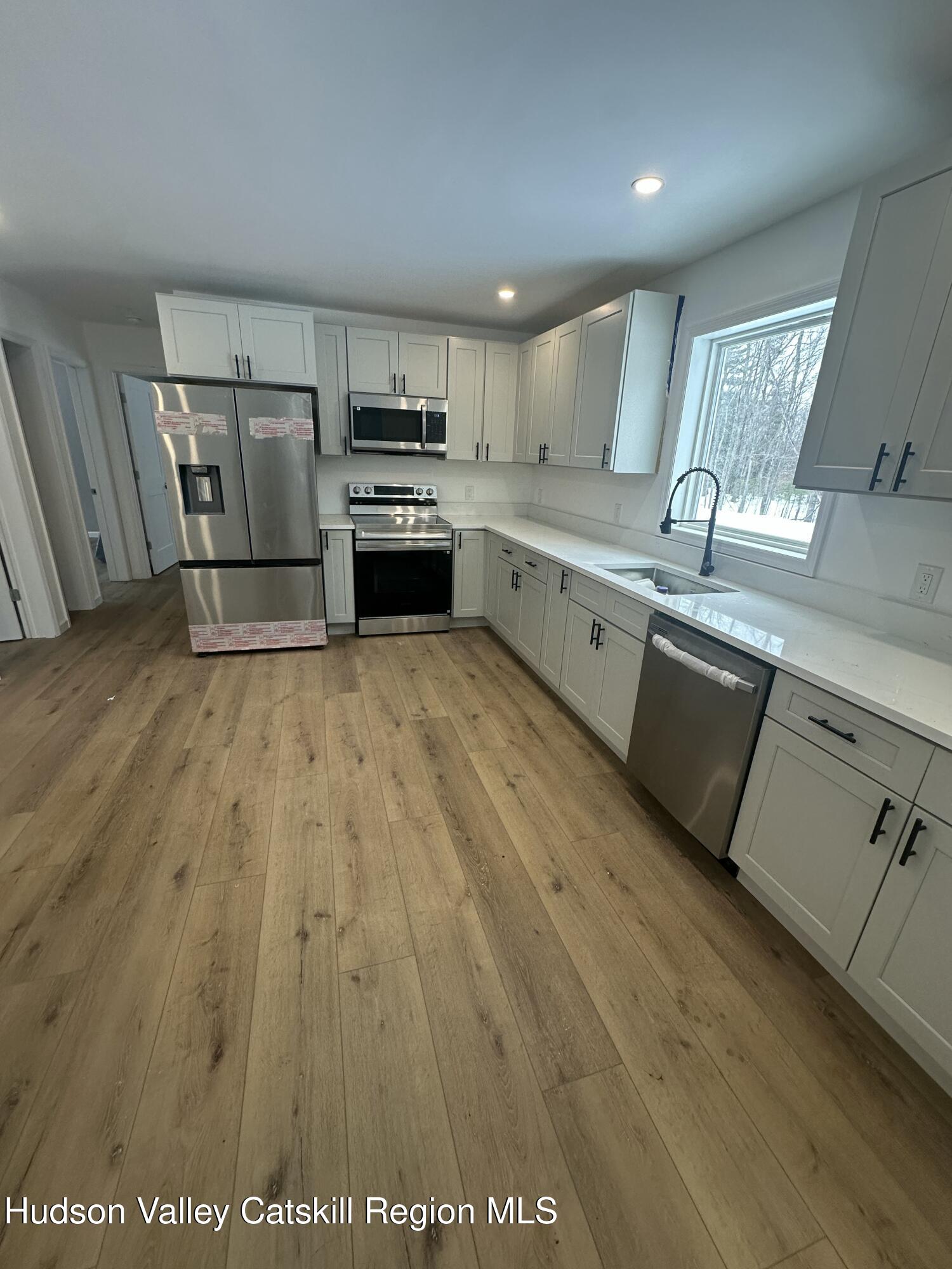 20 Olivers Way Cairo, NY 12413 - Photo 10 of 20 a large kitchen with stainless steel appliances granite countertop a stove a sink white cabinets and a wooden floor