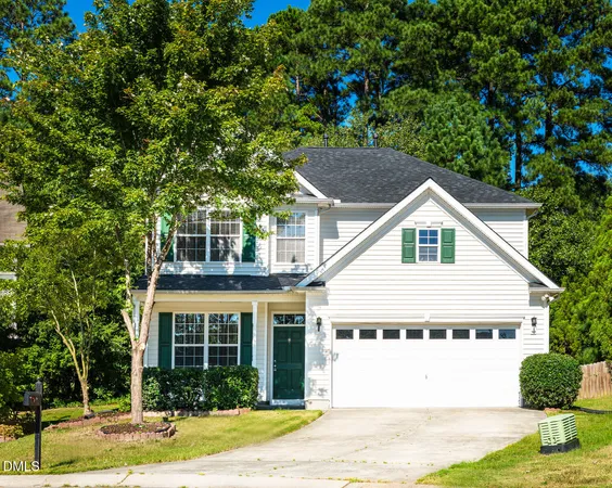 a view of a white house next to a yard