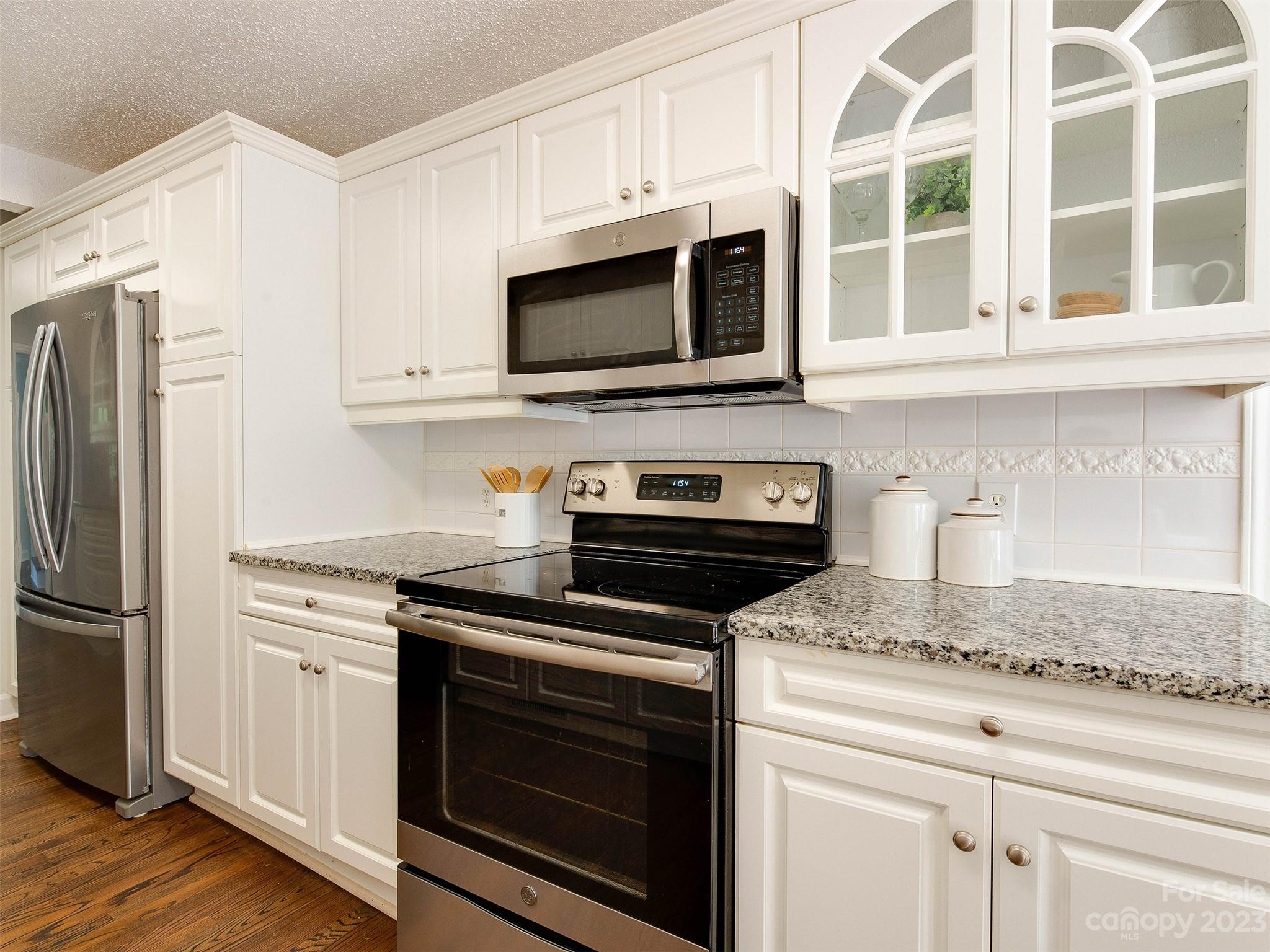 2916 Goneaway Road Charlotte, NC 28210 - Photo 20 of 48 a kitchen with stainless steel appliances granite countertop white cabinets and a stove a oven with wooden floor
