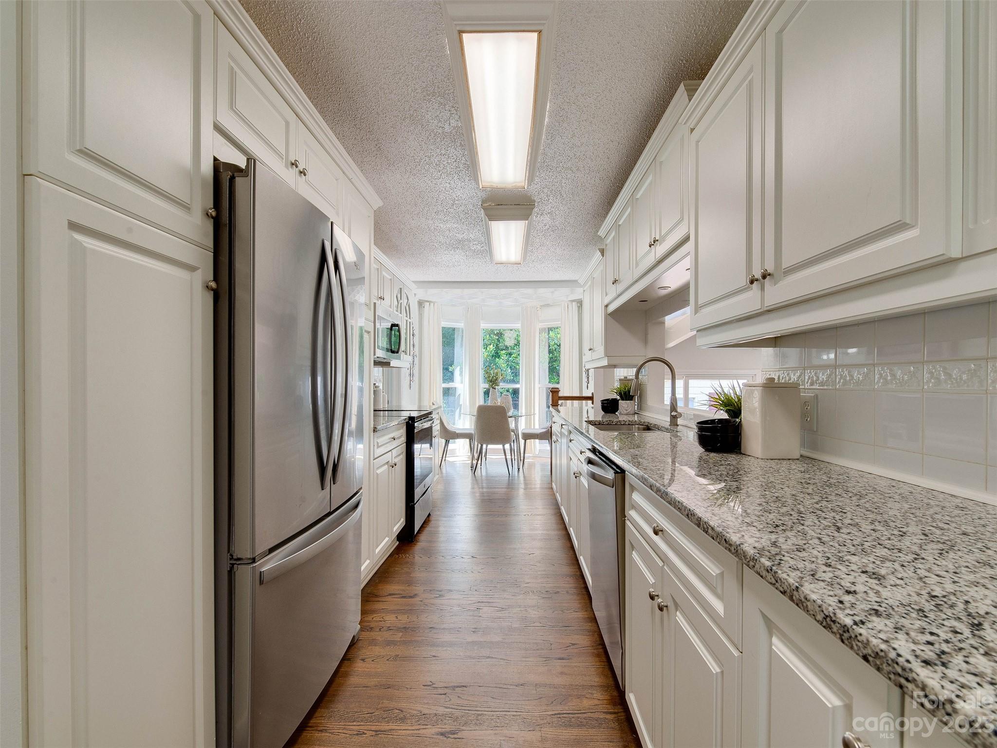 2916 Goneaway Road Charlotte, NC 28210 - Photo 23 of 48 a kitchen with a refrigerator a sink and dishwasher a oven with white cabinets